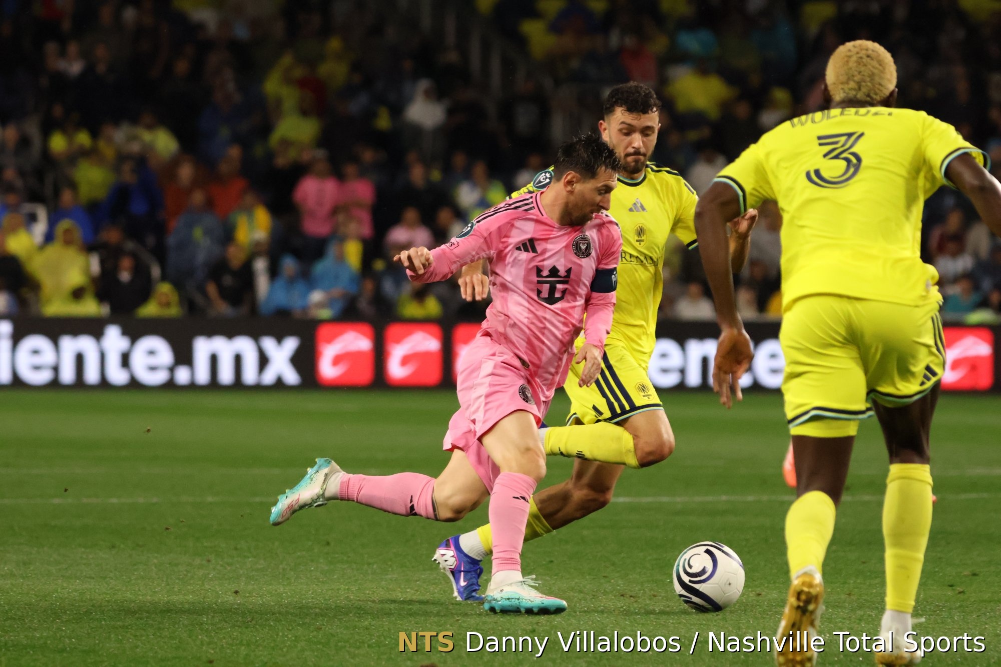 Lionel Messi se interna en el área bajo la presión de Patrick Yazbek y Maxwell Woledzi en Geodis Park