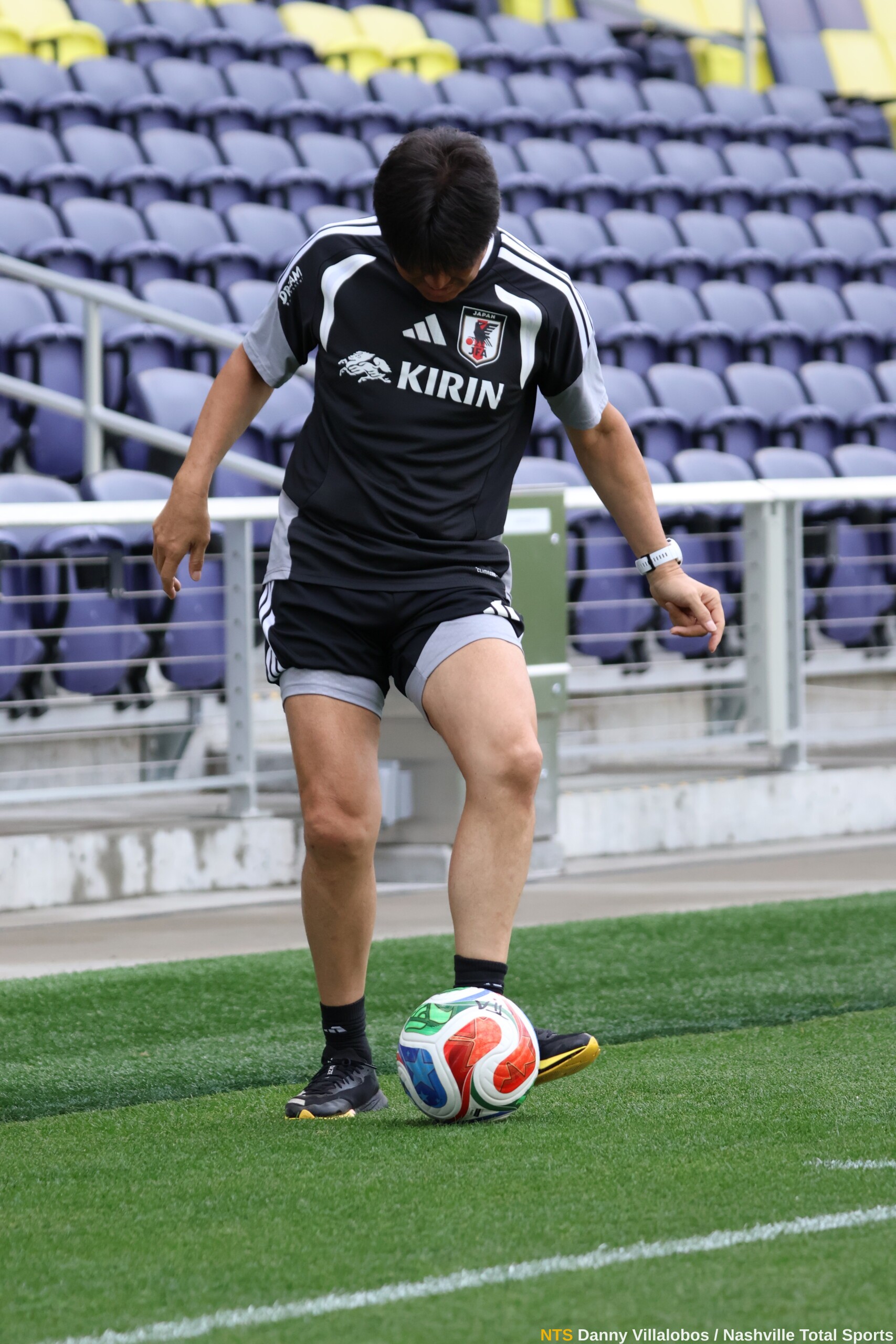 Miembro del cuerpo técnico de Japón controla el balón en GEODIS Park antes del entrenamiento abierto rumbo al Mundial 2026