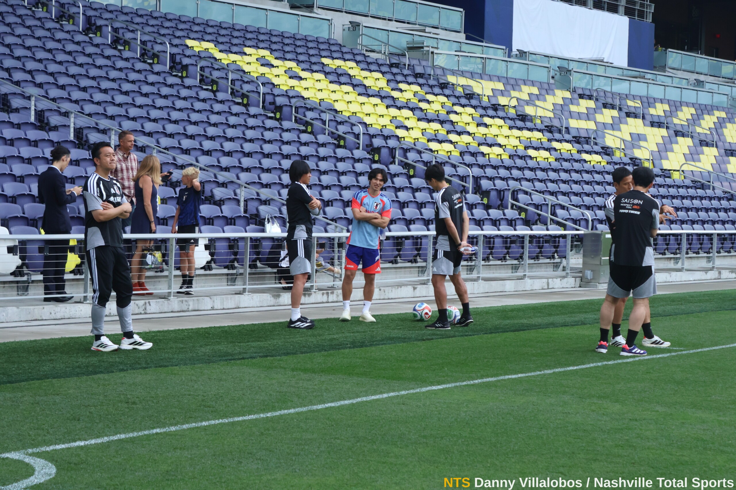 Jugadores de la selección de Japón conversan junto a la banda en GEODIS Park antes del entrenamiento