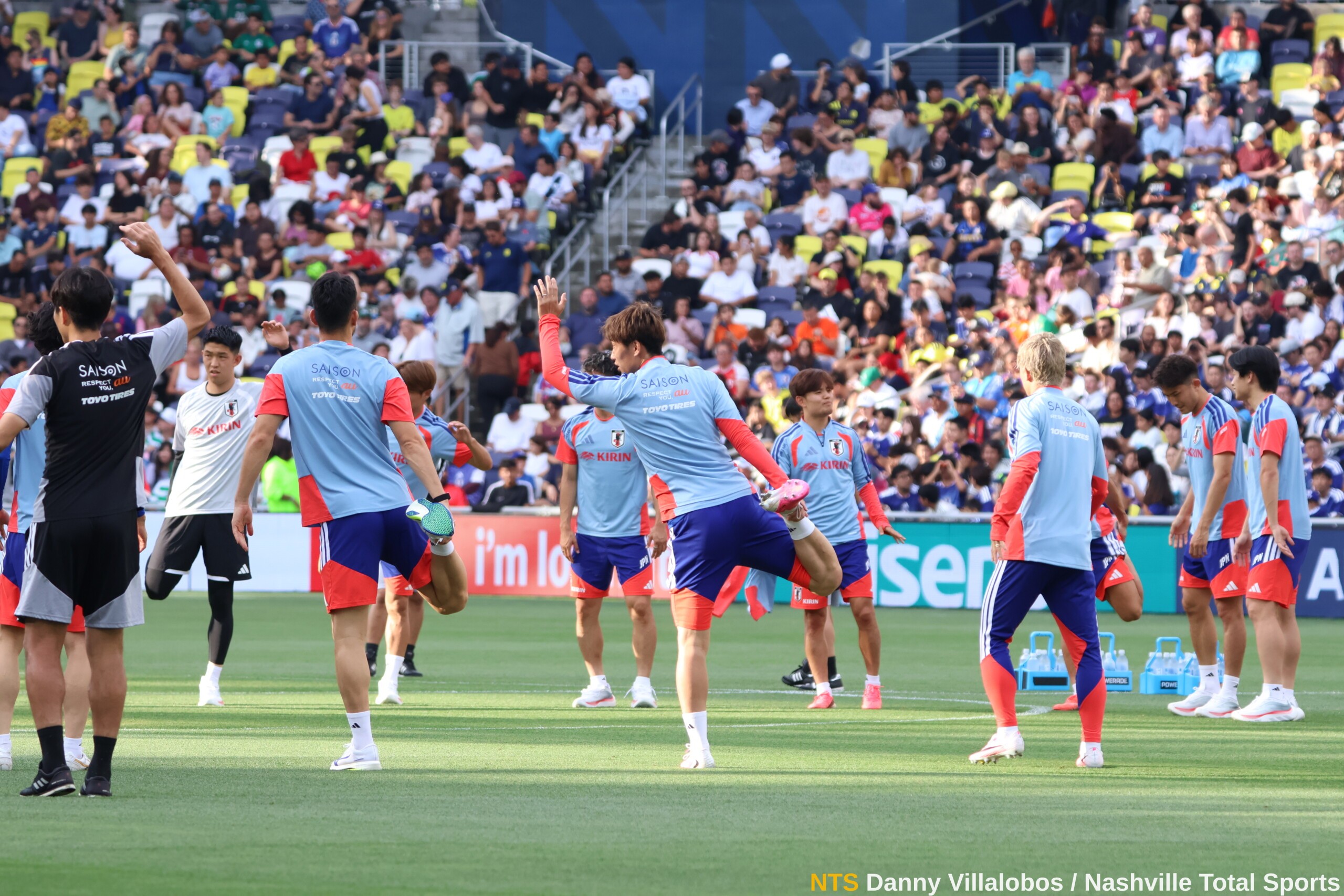 Jugadores de Japón realizan estiramientos frente a la grada llena durante el entrenamiento abierto en Nashville