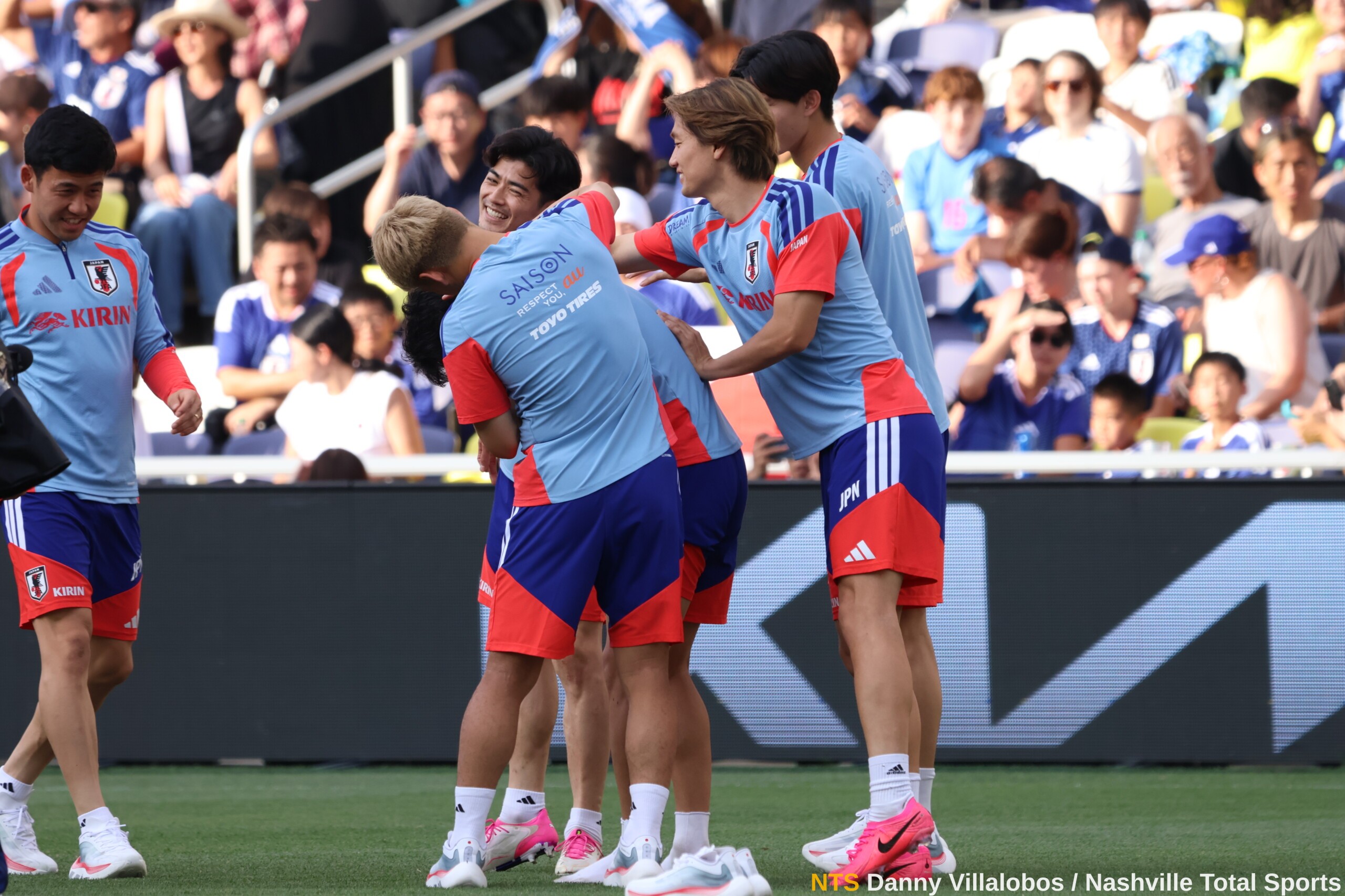 Jugadores de la selección de Japón se abrazan entre risas durante el entrenamiento abierto en GEODIS Park