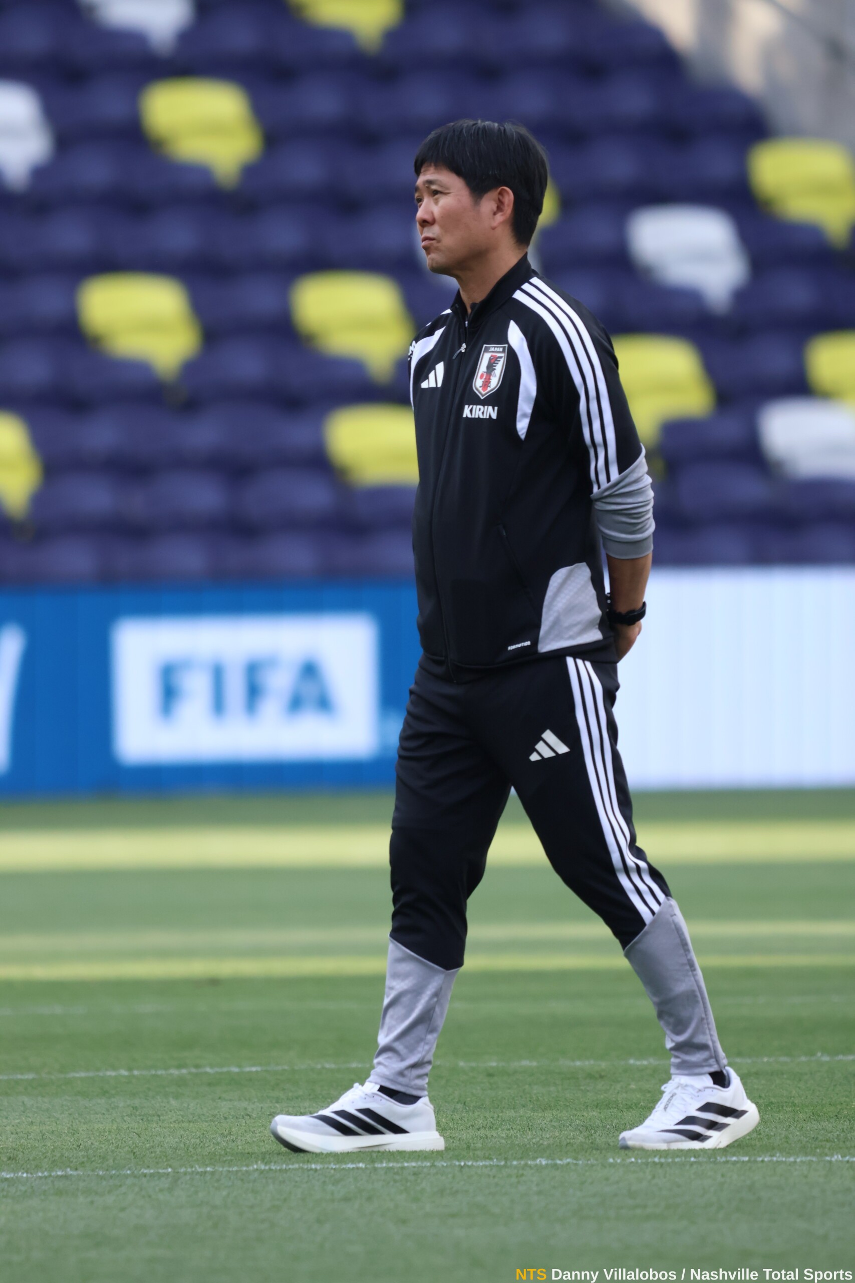 Hajime Moriyasu camina por el césped de GEODIS Park con vallas de FIFA al fondo durante el Mundial 2026