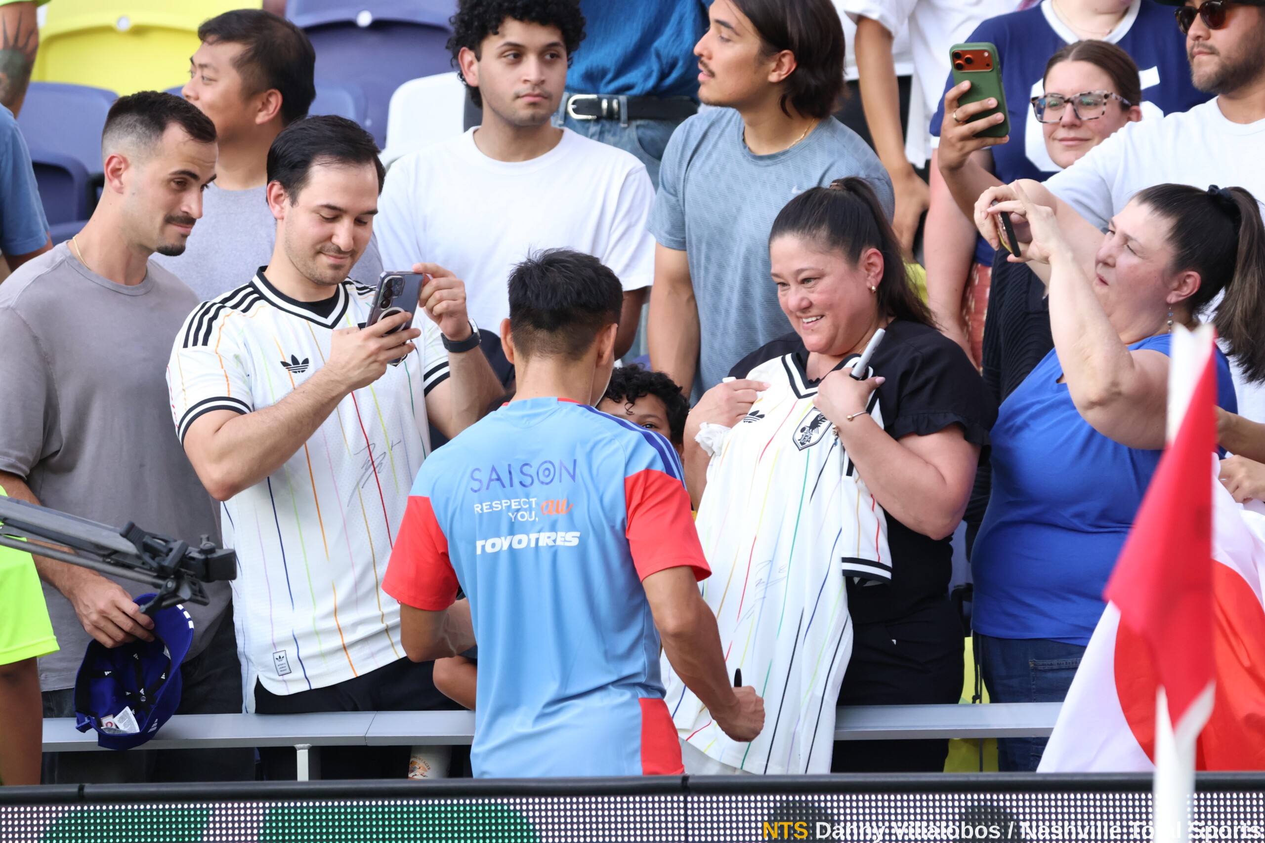 Aficionada sonríe con su camiseta de Japón firmada durante el entrenamiento abierto en GEODIS Park Nashville