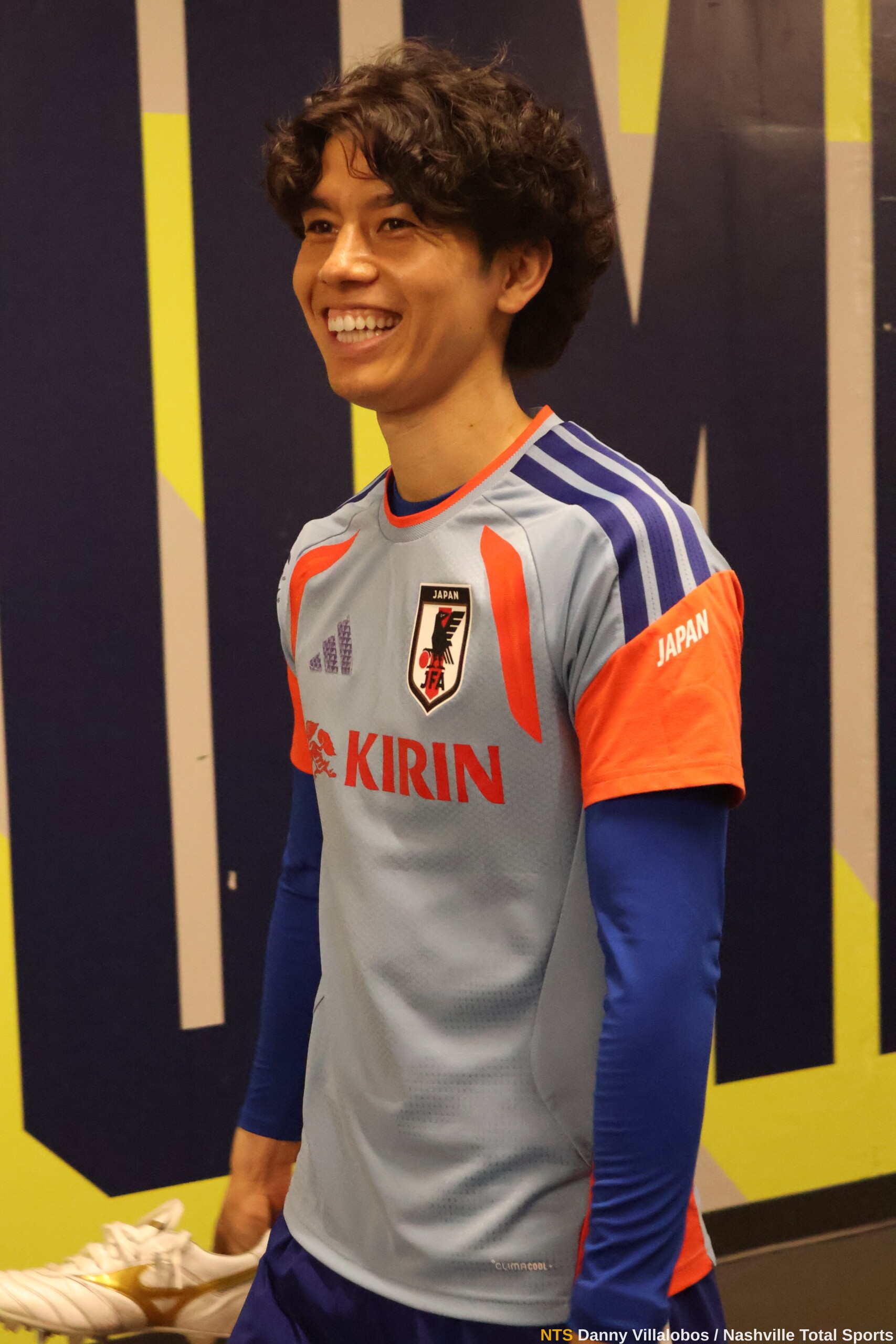 Koki Machida sonríe con sus botines en la mano en la zona mixta tras el entrenamiento de Japón en Nashville