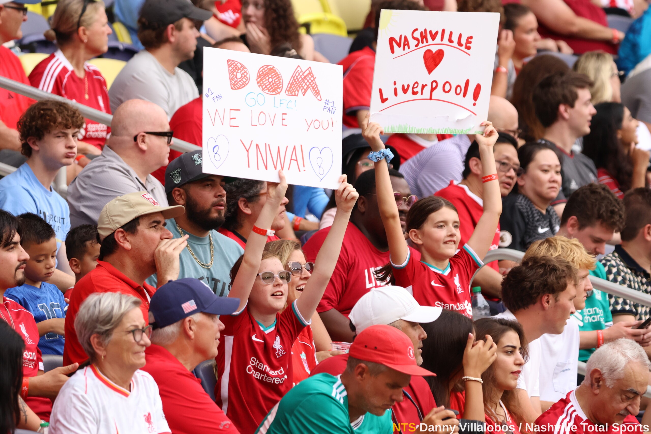 Aficionados con pancartas DOM te amamos, YNWA y Nashville ama a Liverpool