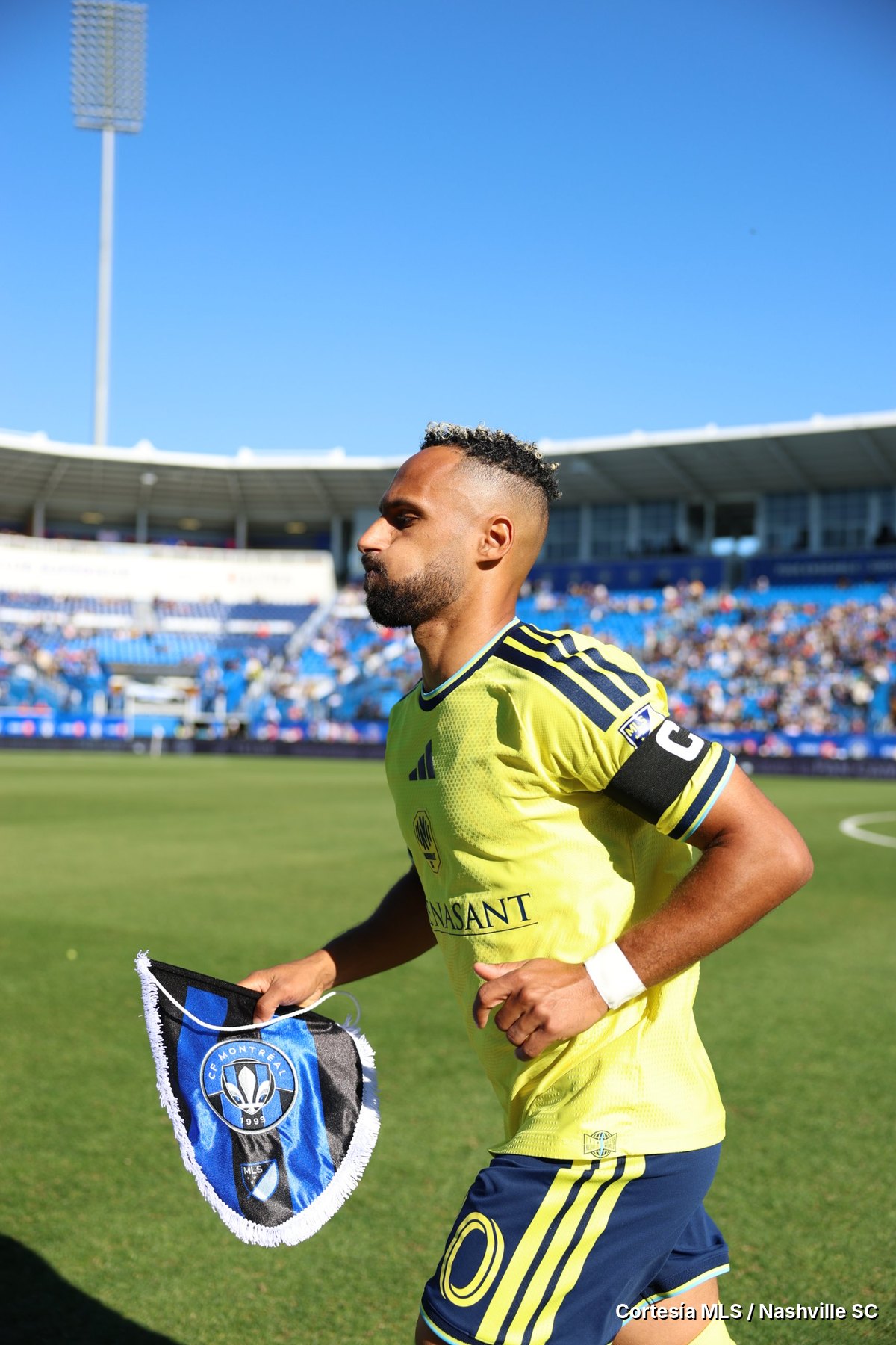 Hany Mukhtar, capitán de Nashville SC, con el banderín de CF Montréal